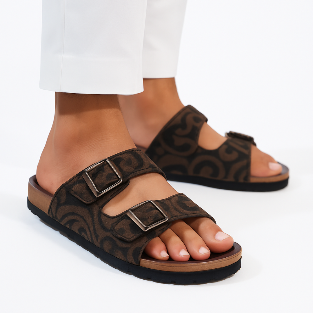 Brown sandals with buckles worn by a person on a white background